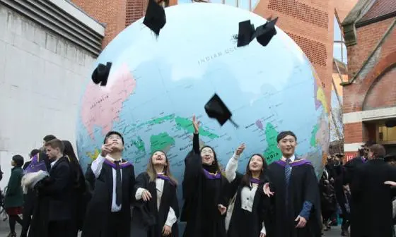 Graduates in front of LSE globe
