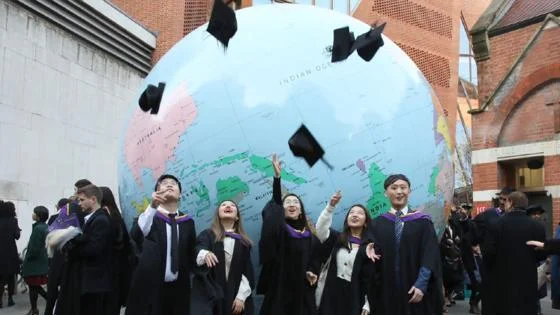 Graduates in front of LSE globe