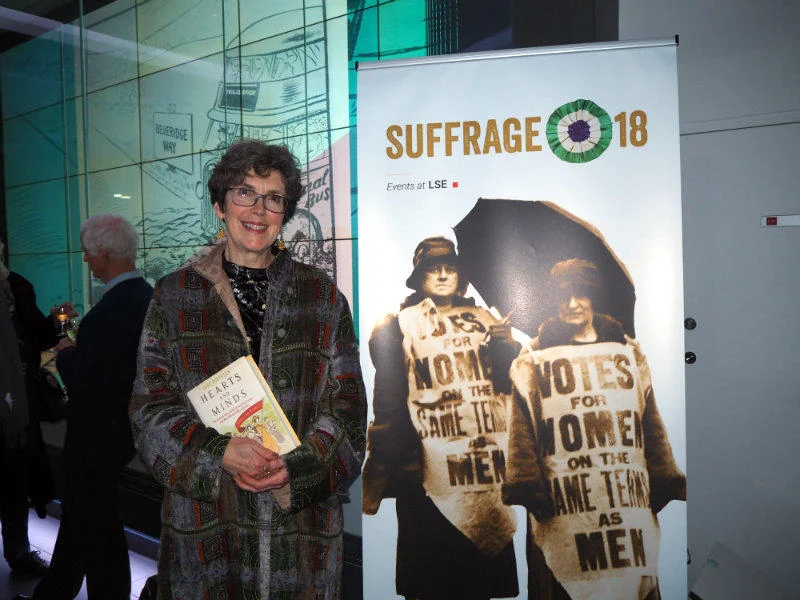 an author holding a book in the LSE Library exhibition space
