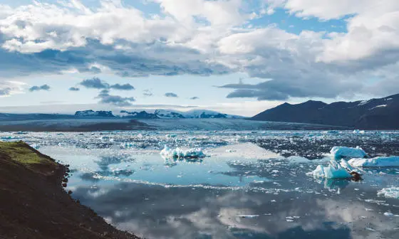 glacier with clouds reflecting on surface