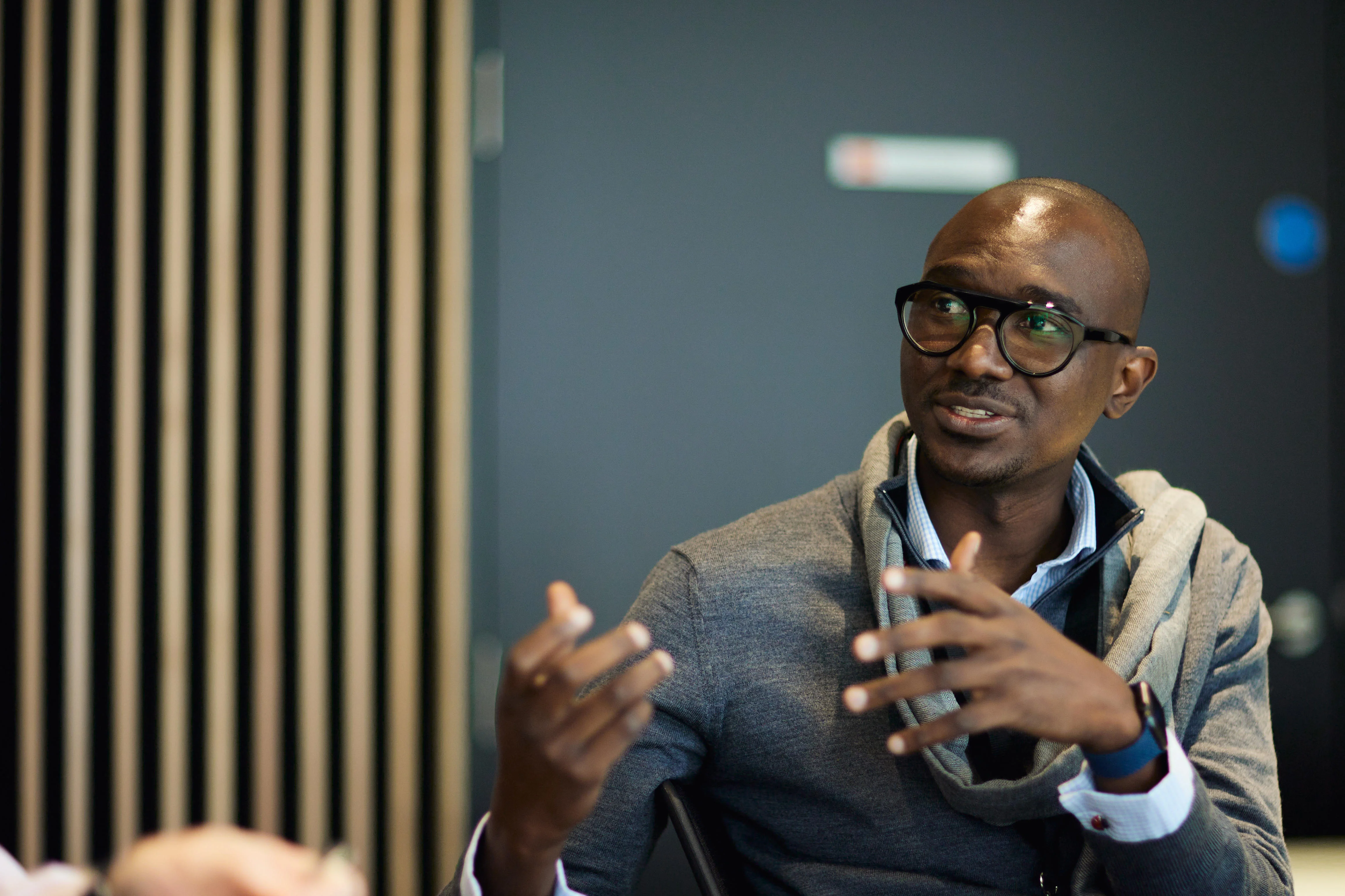 Male student learning in class gesturing with his hands.