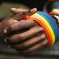 man with rainbow flag over hands