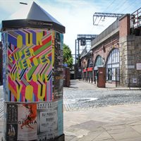 Street in Manchester with colourful poster on wall