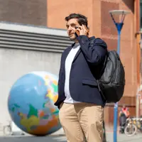 Mature student talking on the phone in a blazer in front of a globe