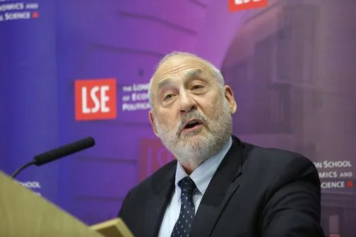 Joseph Stiglitz speaking in front of an LSE banner.