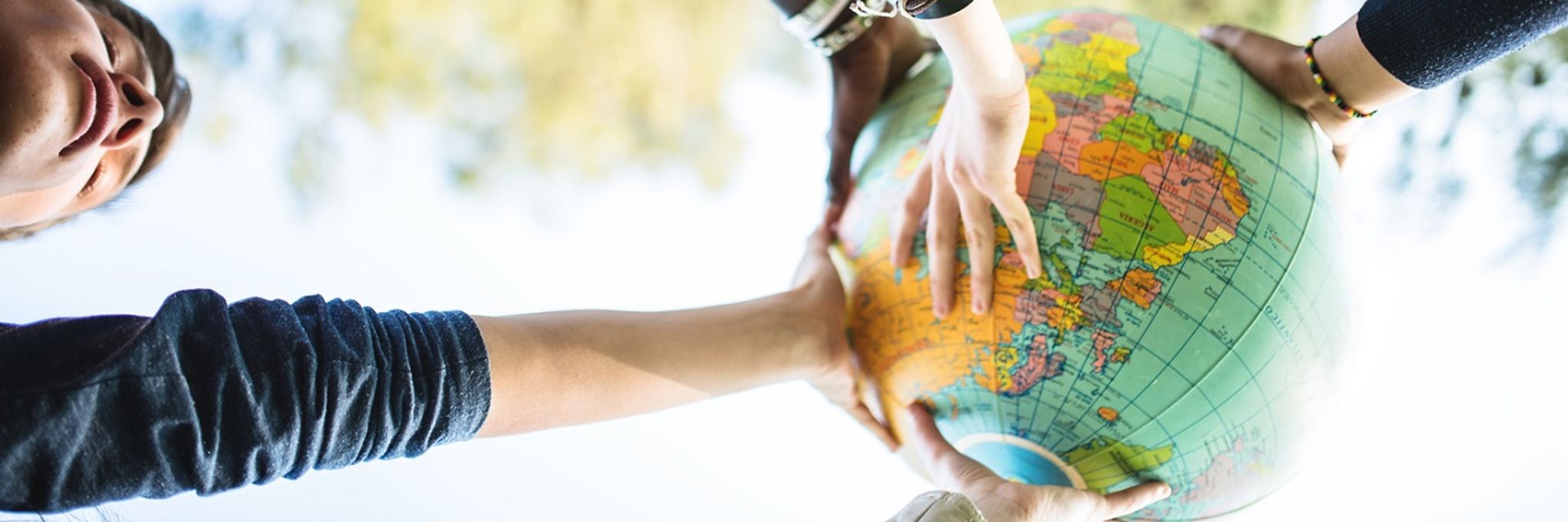 Hands reaching out to touch a globe