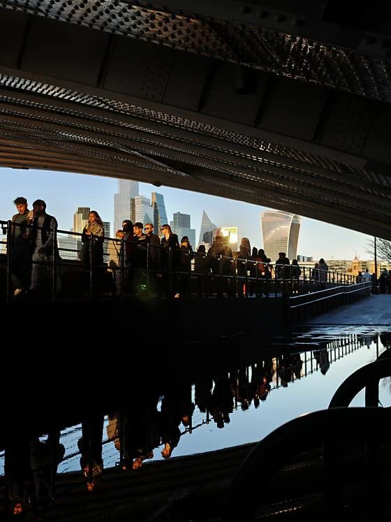 people walking under bridge by Thames