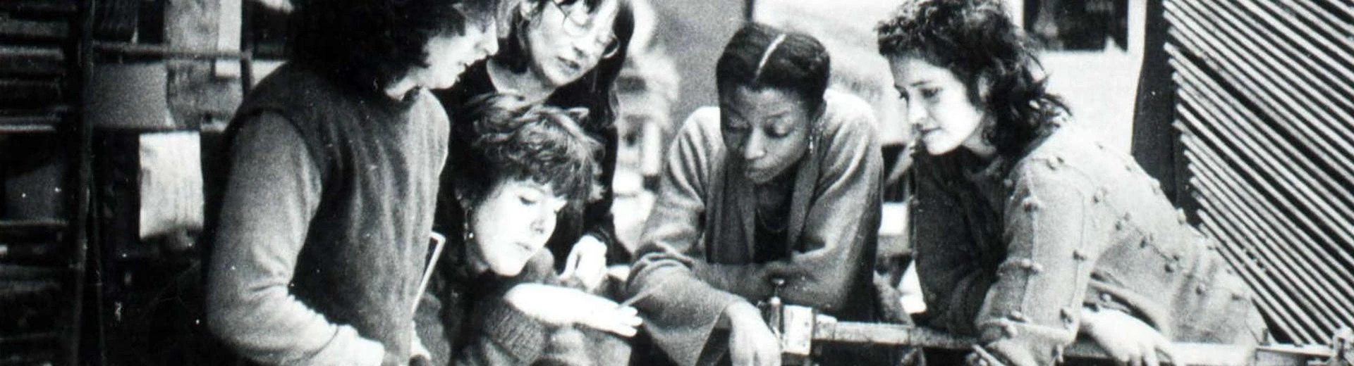 A group of 5 women working on and discussing something related to design.