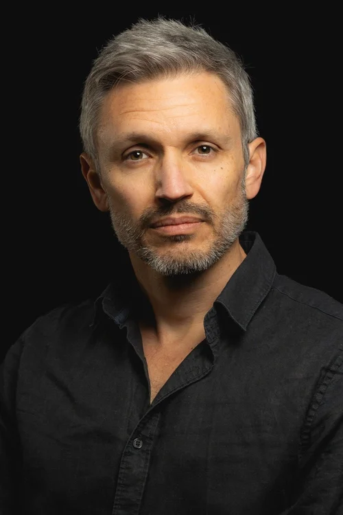 Headshot of Jason Hickel wearing a black shirt.