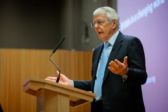 John Major speaks at a lectern at LSE