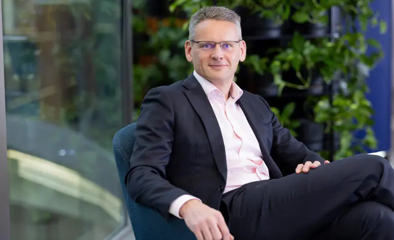 John Mark Pettigrew sits in a chair looking confidently out to the viewer