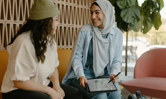 Two women talking with tablet