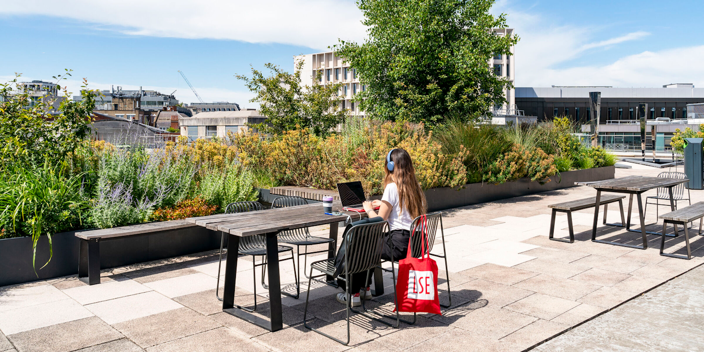 Decorative image: Student using a laptop in an outdoor campus space