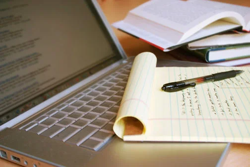 Photo of a laptop computer with open books