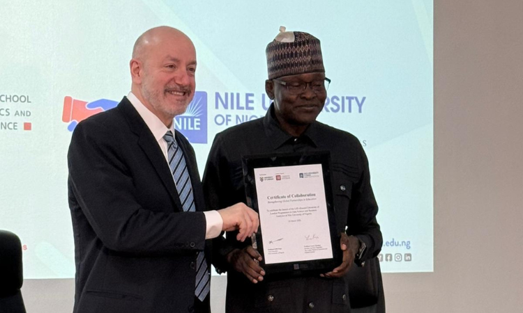Larry Kramer poses with a Certificate of Collaboration with dignitary from Nile University