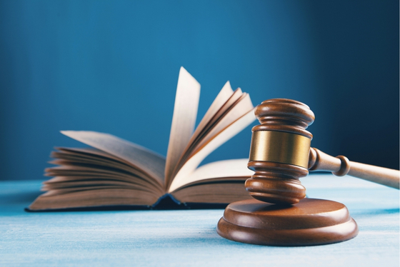 Open book beside a wooden judge’s gavel.
