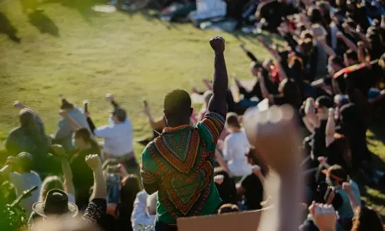 Protestors at a meeting raising their arms in solidarity
