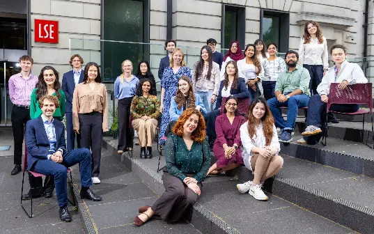 A large group of students on steps outside an LSE building