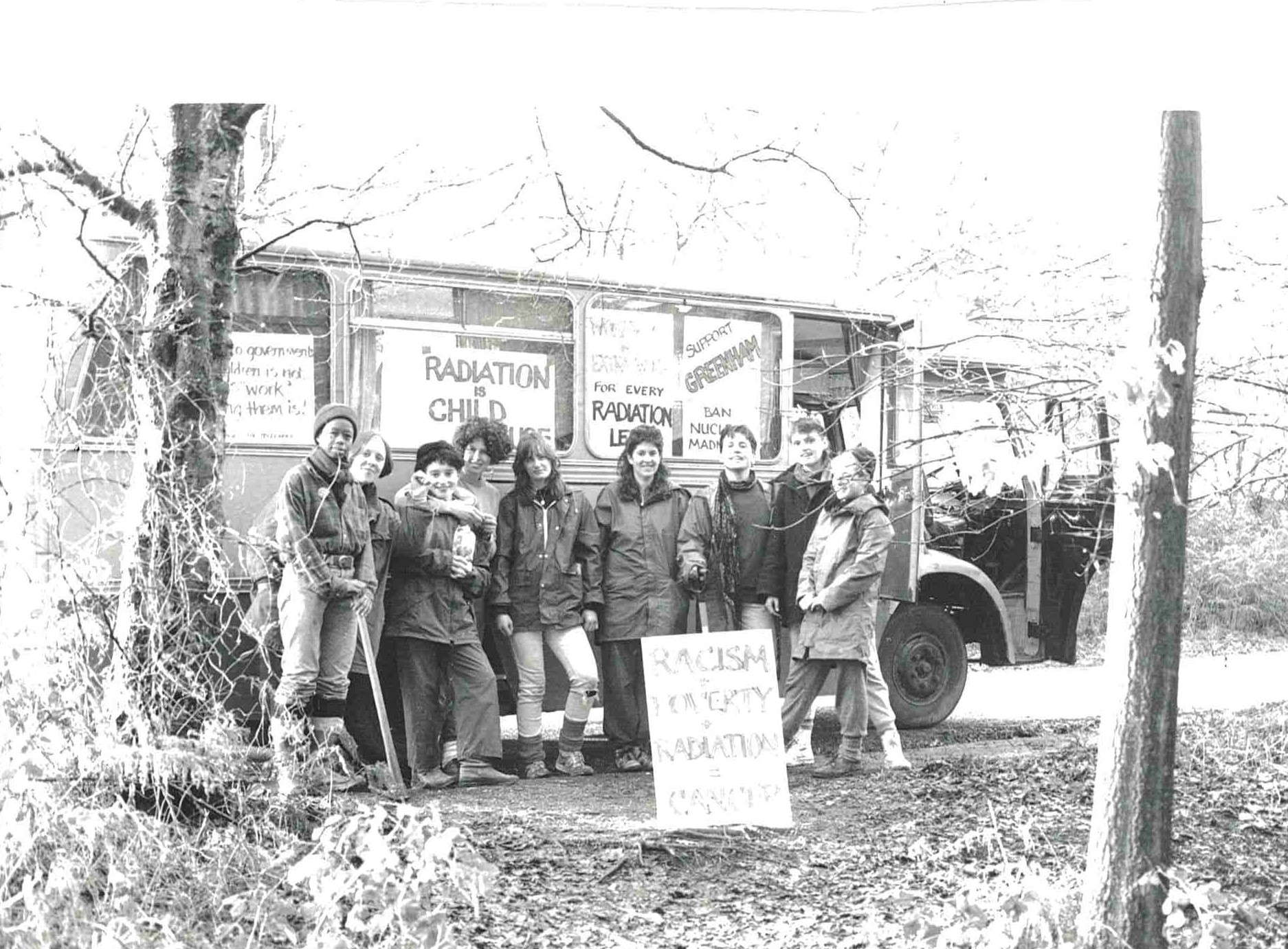 A group of people with placards stood in front of a bus.