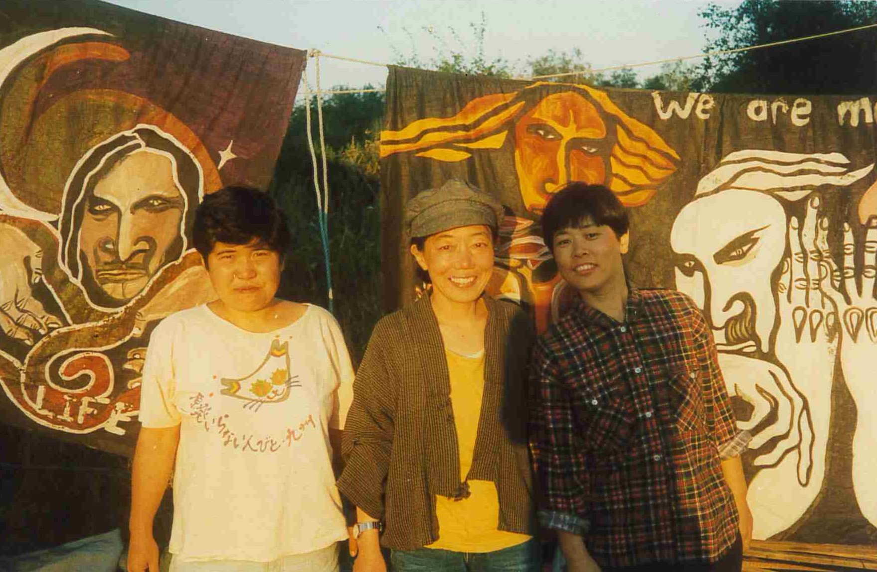 Three people stood together in front of banners. 