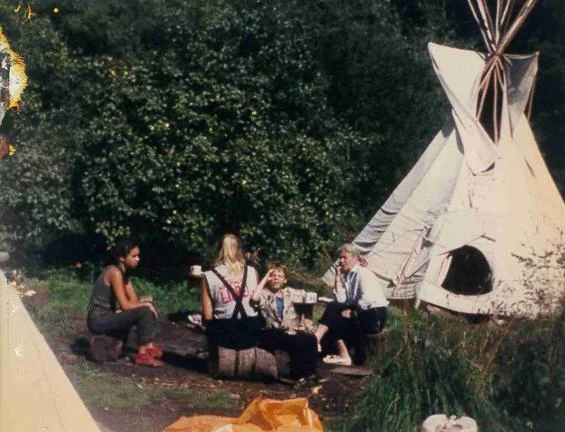 People sat around outside a tent.