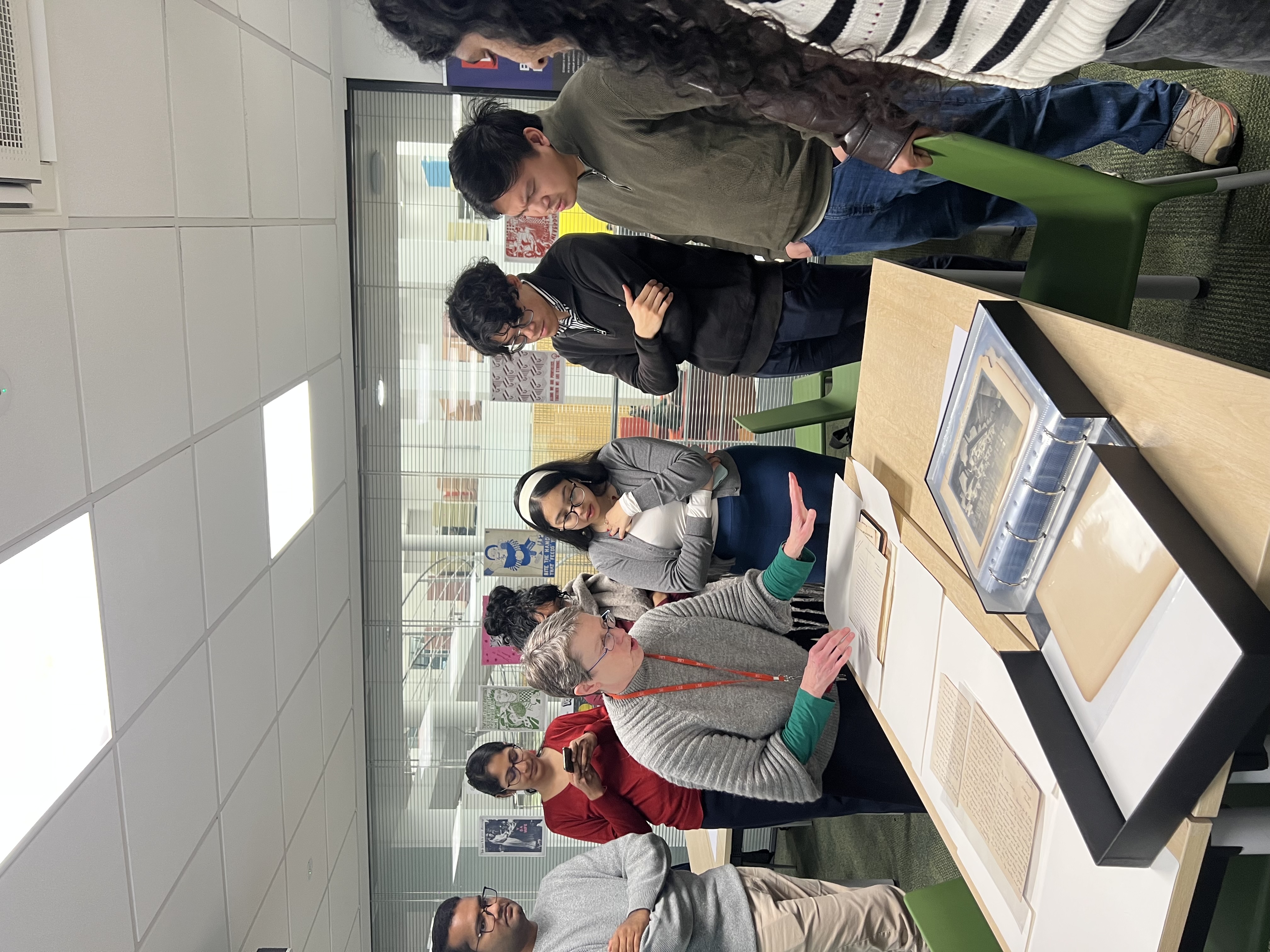 A group of people looking at original archives with a curator.