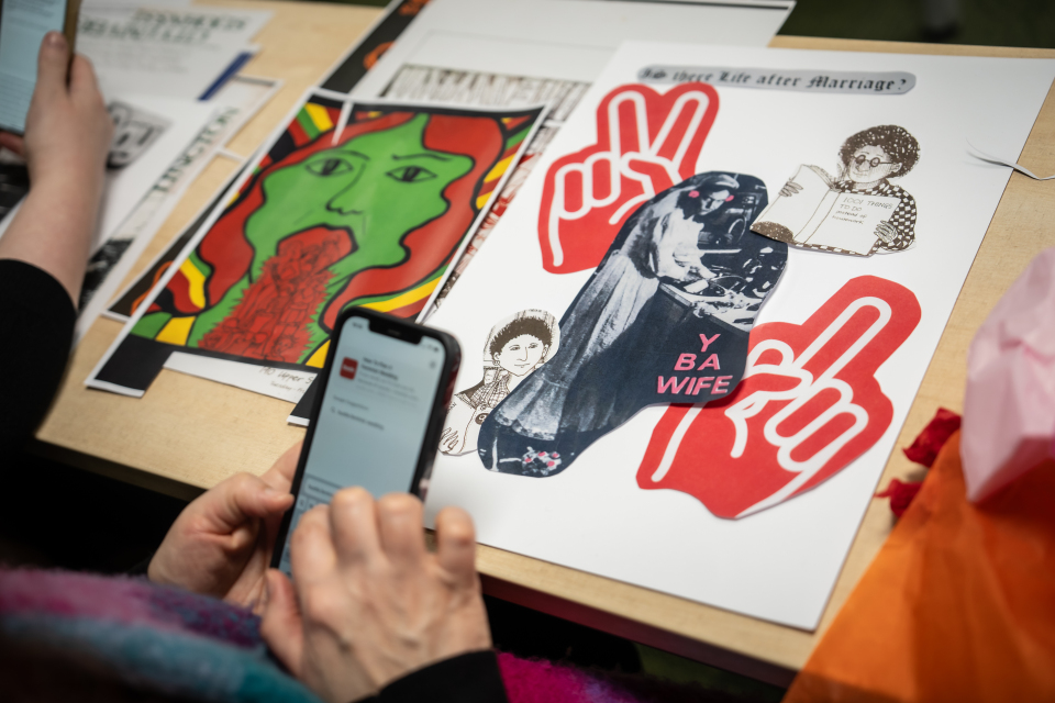 Items on a desk in front of someone using a mobile phone.