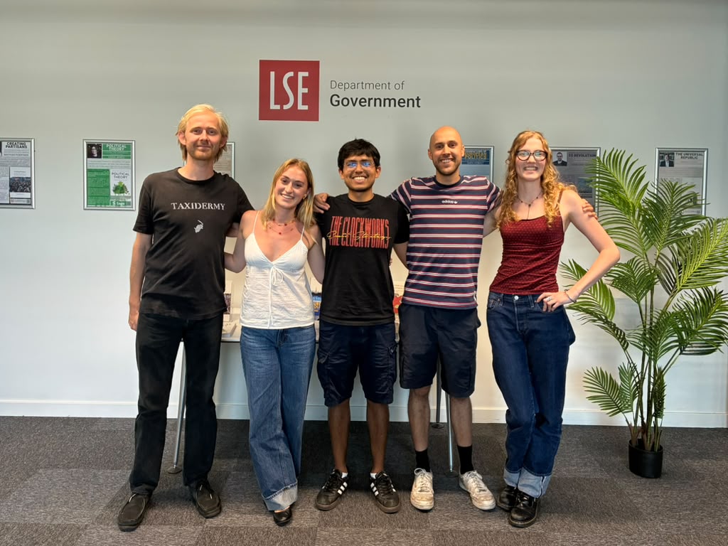 Five people stood arm in arm smiling