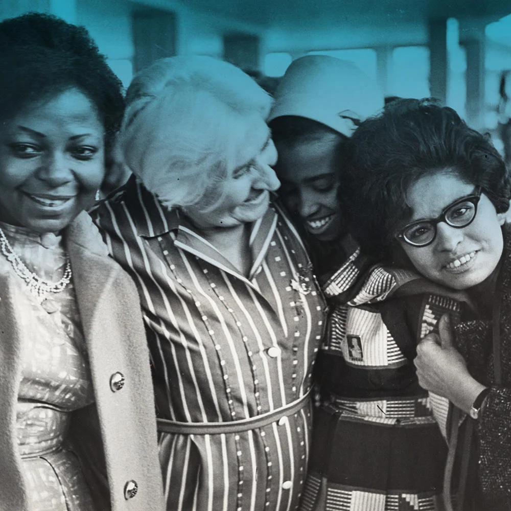 Four women smiling and stood together