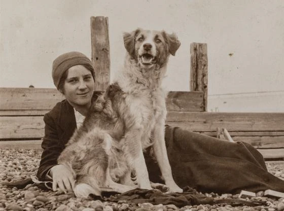 Elsie Duval laying on a beach with a dog