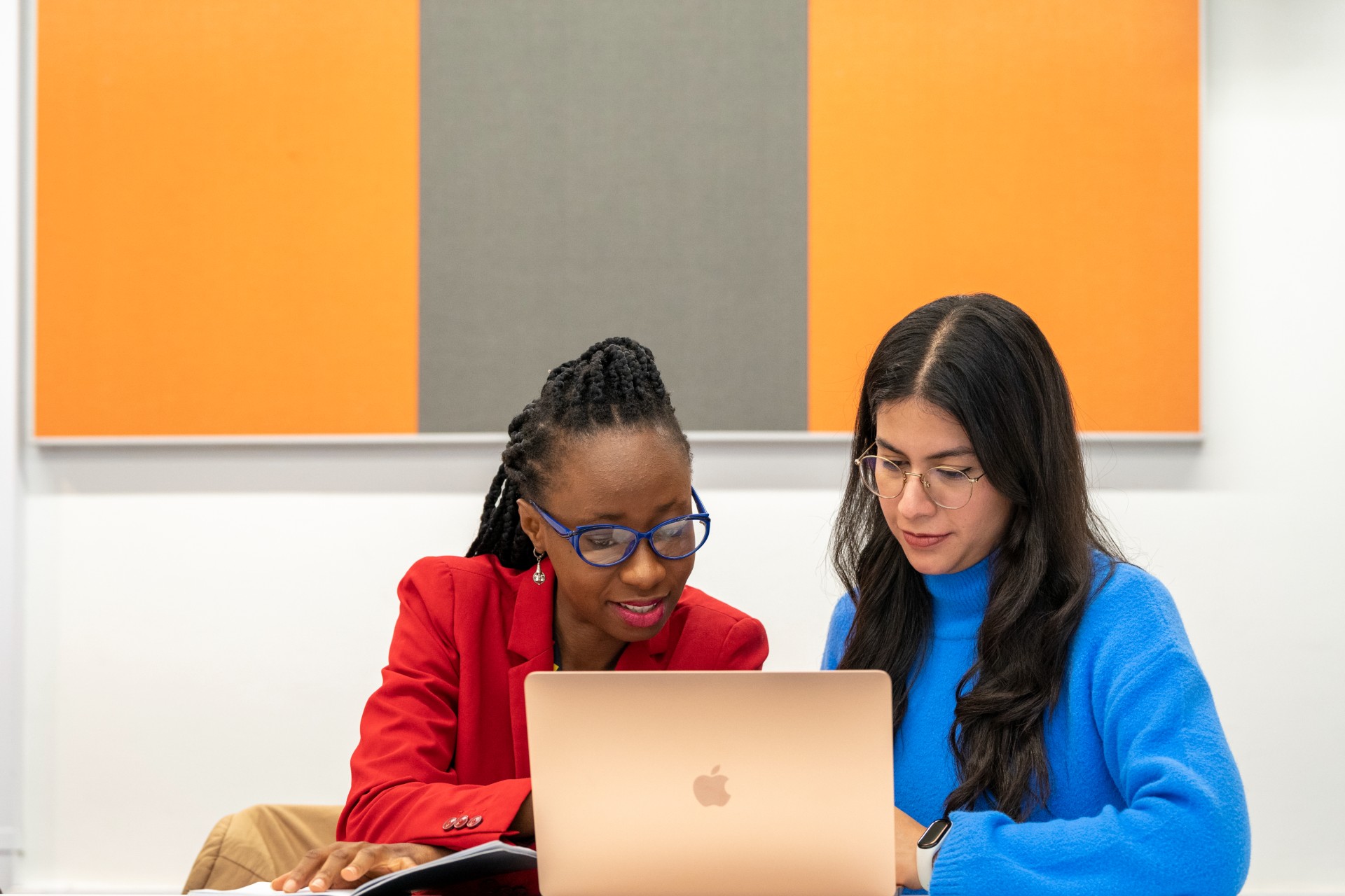 Two students at a laptop working
