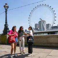 three people chatting in front of the London eye