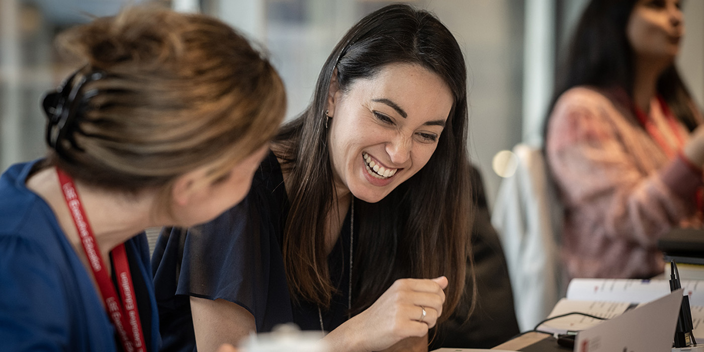 Two women smile while in a class at LSE