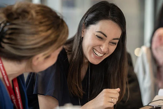 Two women smile during a class at LSE