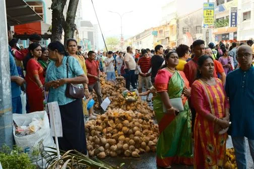 A crowd of people gathered in the street, waiting.