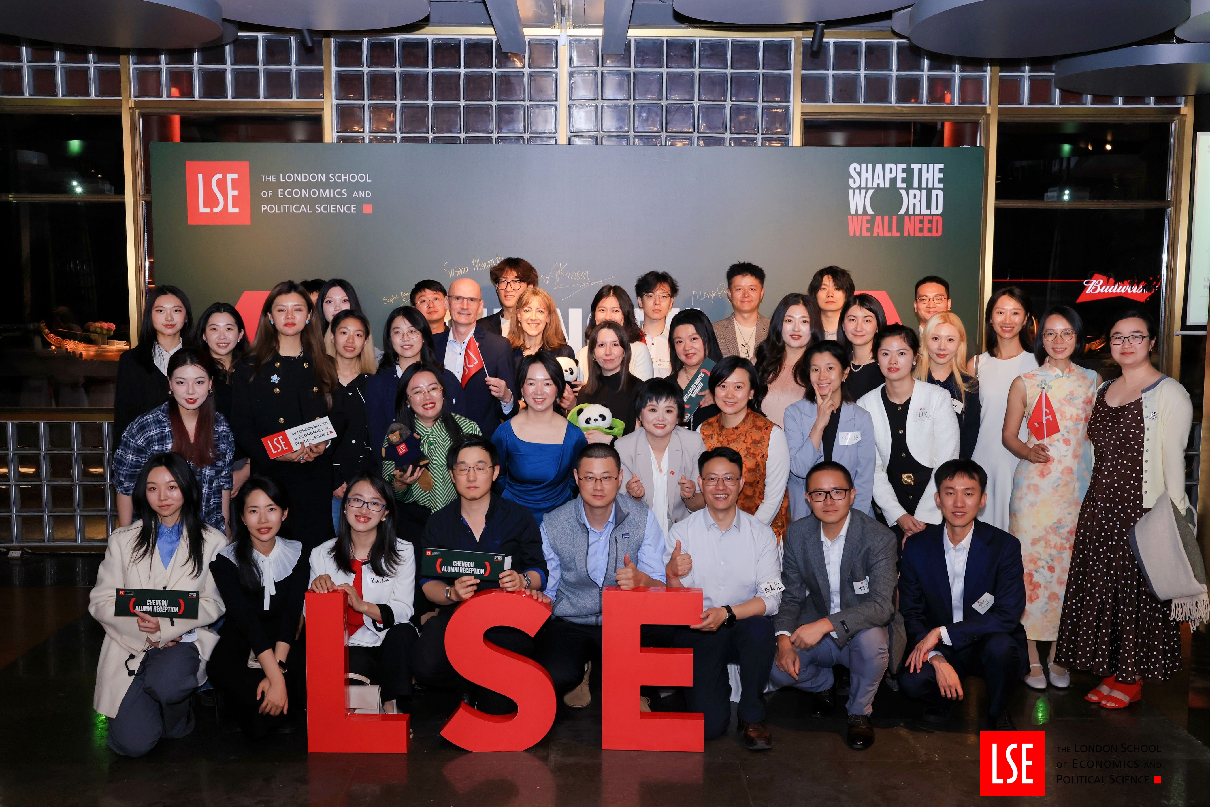 Group of LSE alumni in Chengdu, China, in front of LSE red letters