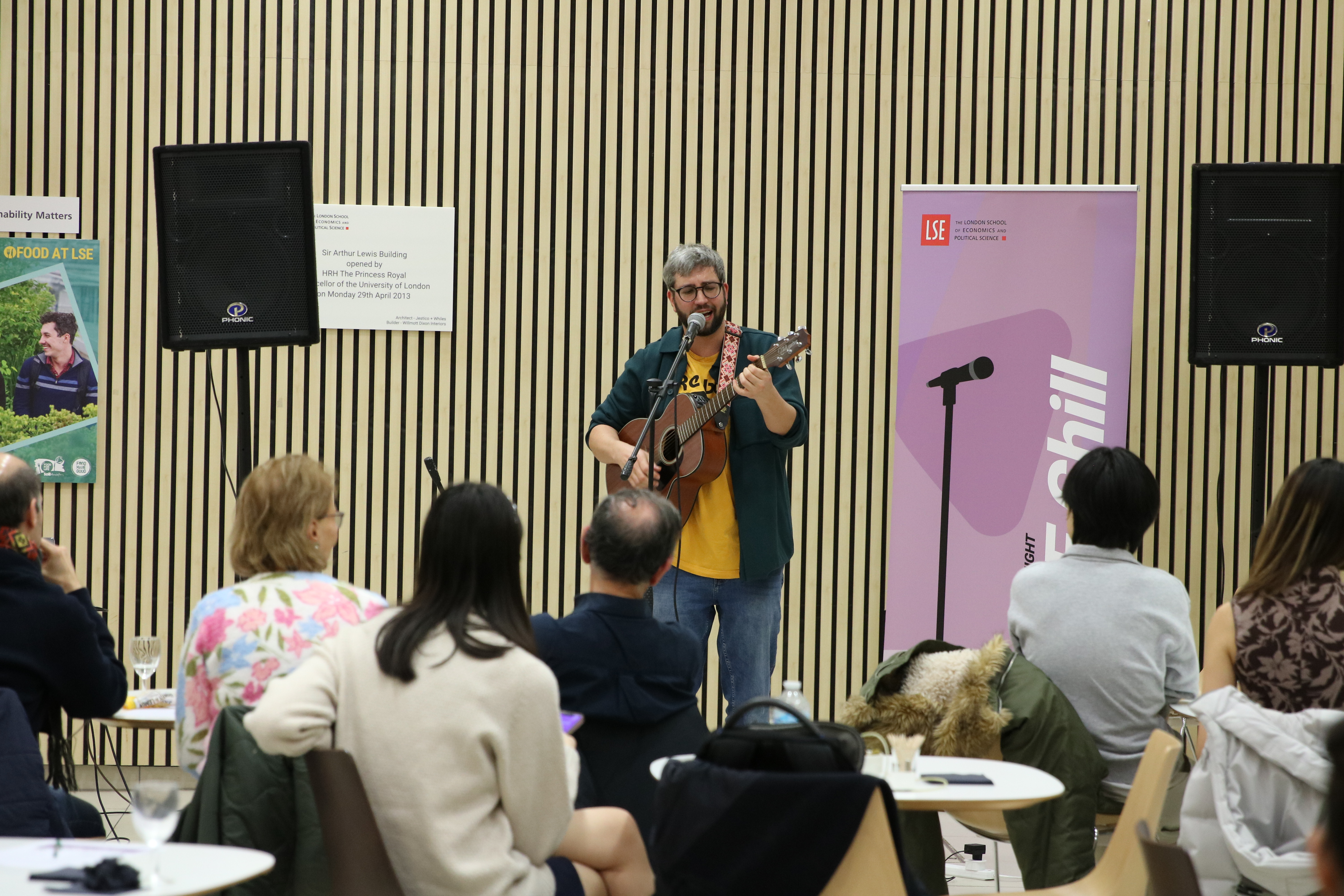Student plays guitar in front of crowd at LSE Chill