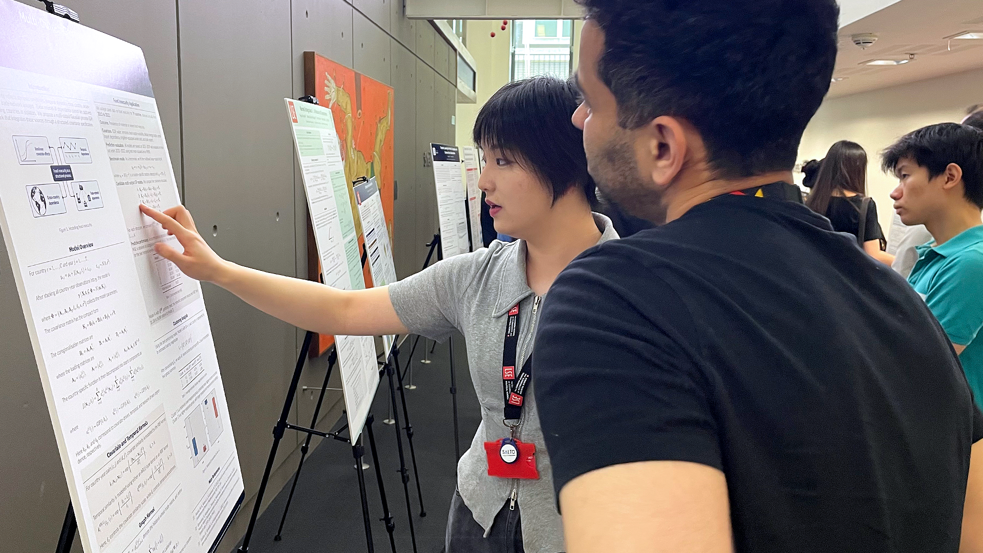 PhD students looking at research showcase posters