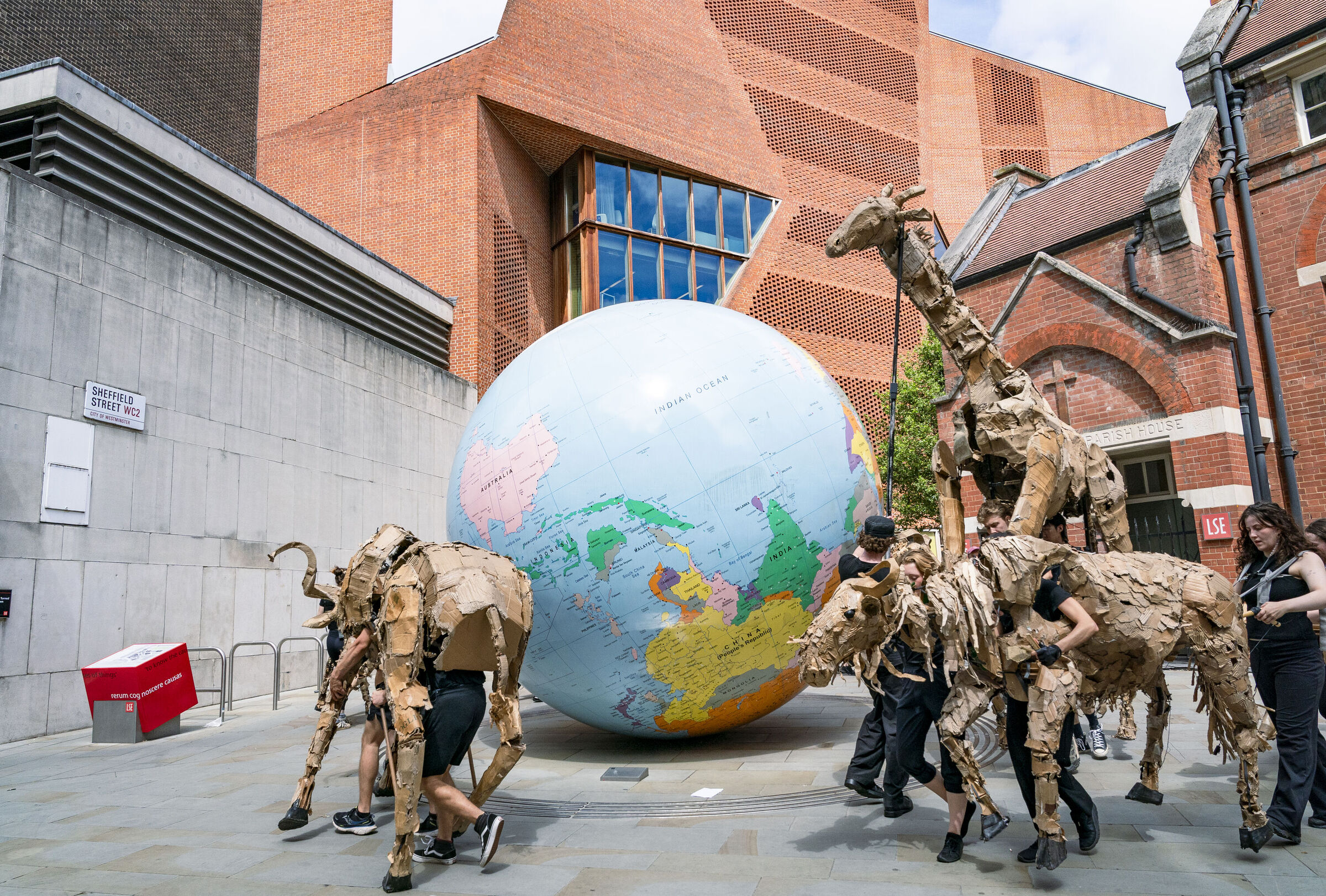 THE HERDS puppets on LSE campus around the World Turned Upside Down globe