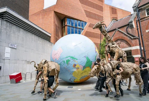 THE HERDS puppets on LSE campus around the World Turned Upside Down globe