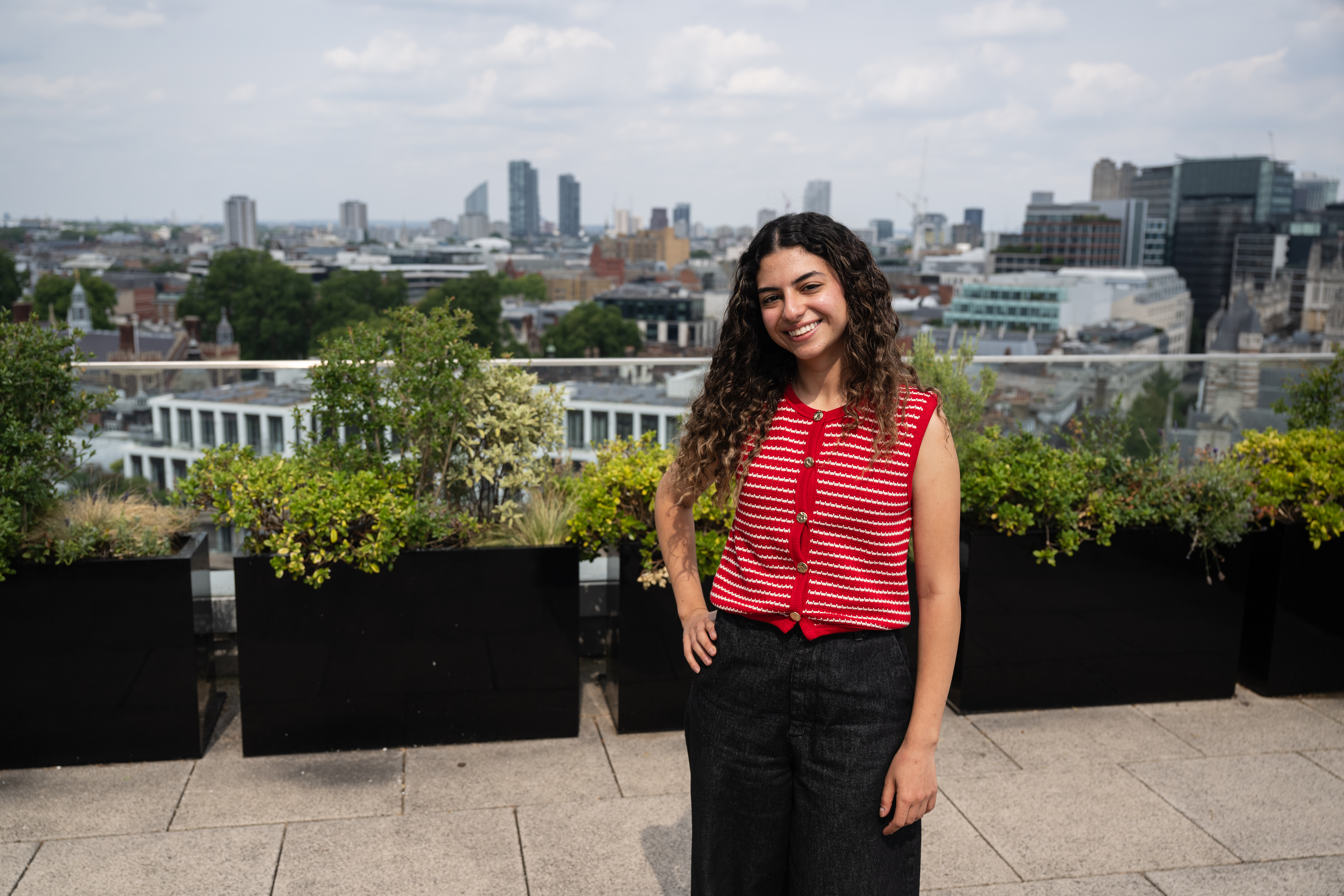 Student standing on a roof terrace with a view of London