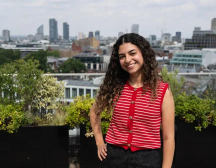 Student standing on a roof terrace with a view of London