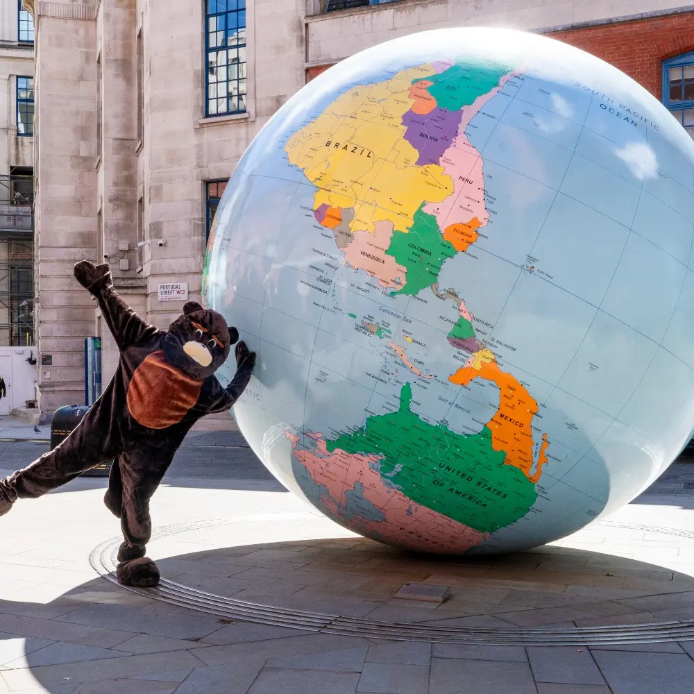 LSE beaver poses by globe