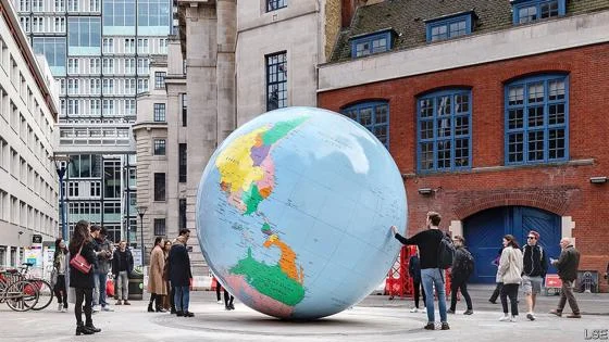 People looking at the LSE globe installation on the LSE campus