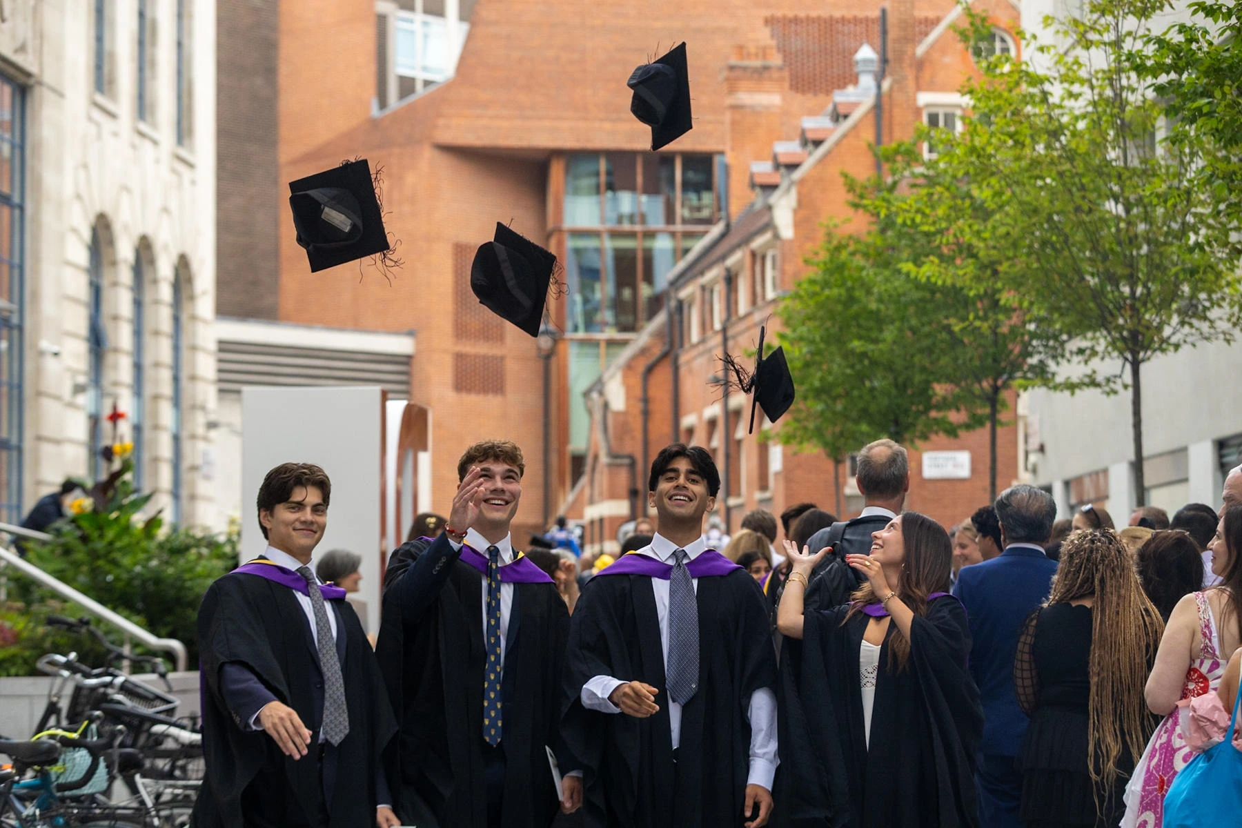 Graduates throwing their hats up on campus.