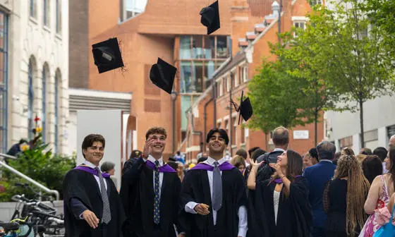Group of LSE graduates throwing caps in the air