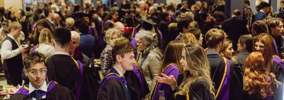 Graduates talking to each at the Graduation ceremony reception.