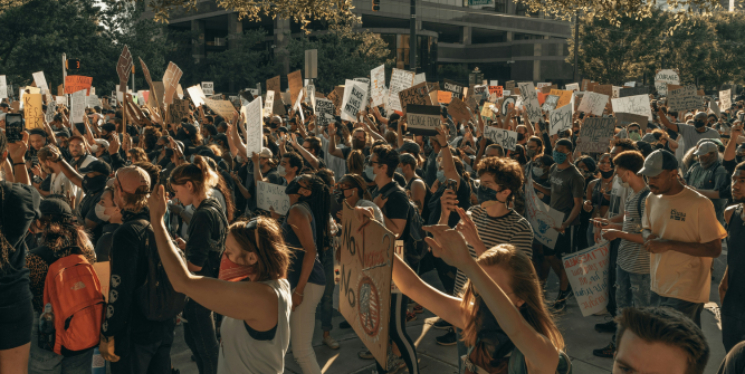 A crowd of people holding up posters during a protest.