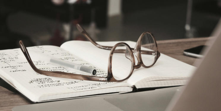 Spectacles kept on top of an open book
