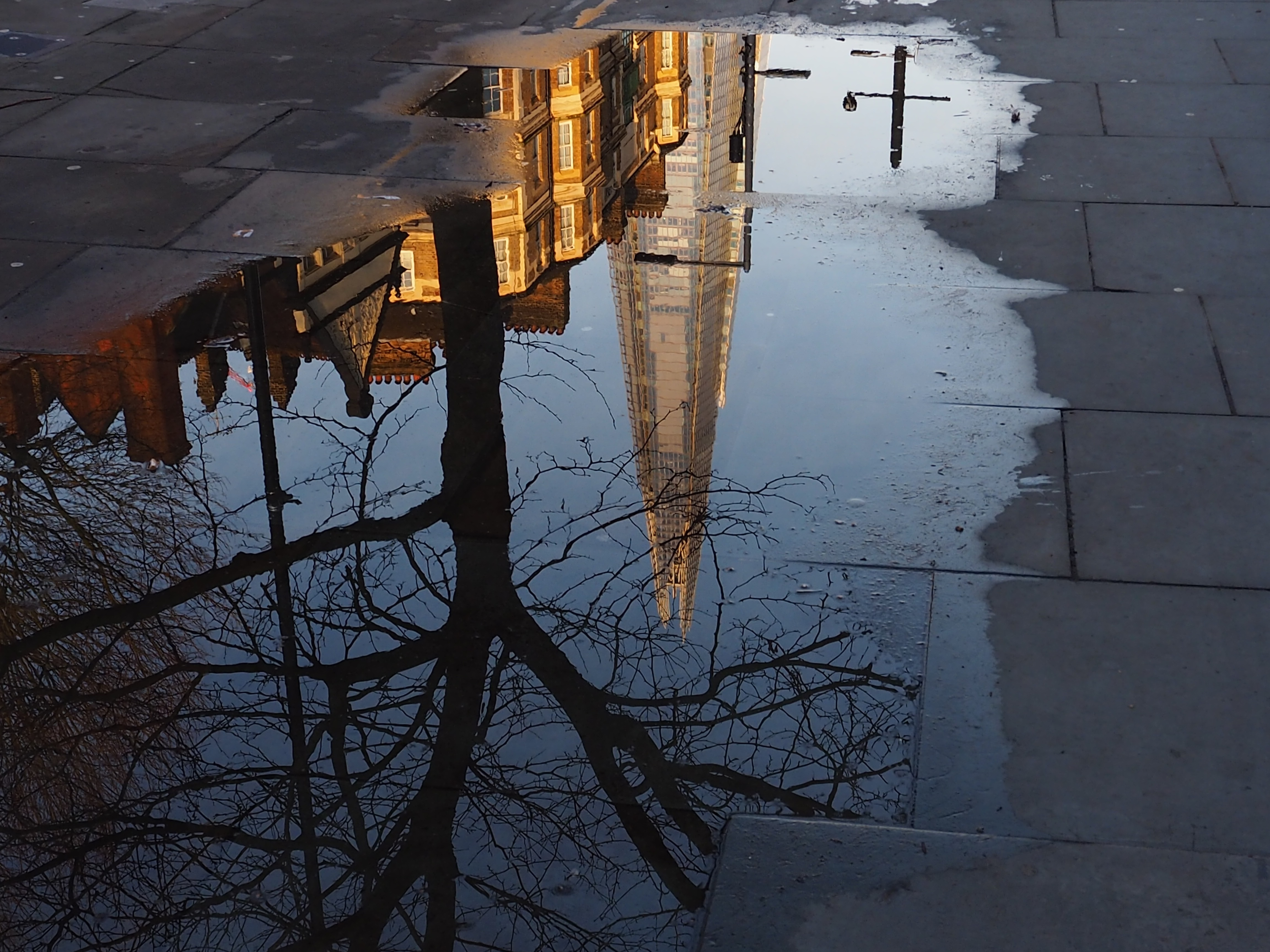 reflection of the shard in a puddle